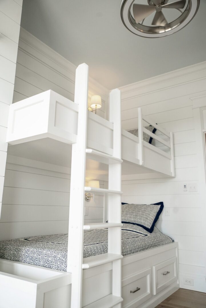 A double deck bed with white frames